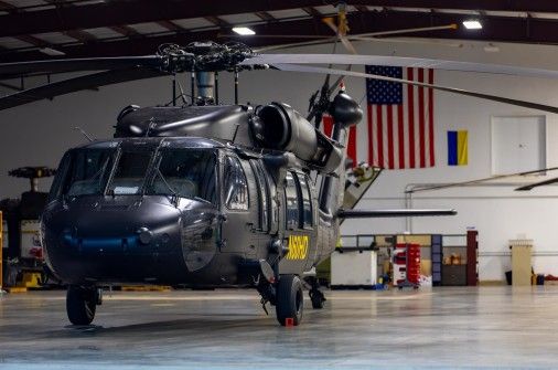UH-60 Black Hawk in hangar — American flag backdrop