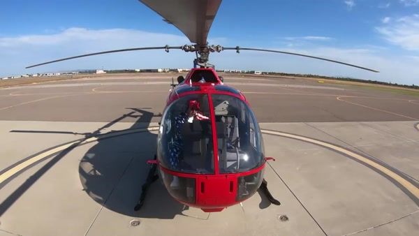 Red R22 helicopter front-on with American flag